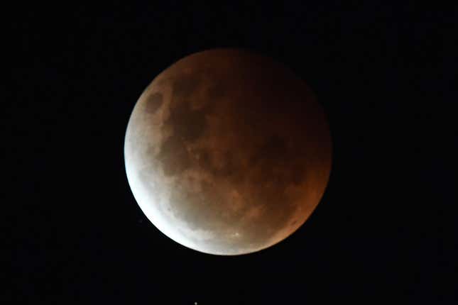 The full moon is seen during the partial eclipse in Sydney on May 26, 2021 as stargazers across the Pacific are casting their eyes skyward to witness a rare "Super Blood Moon". 