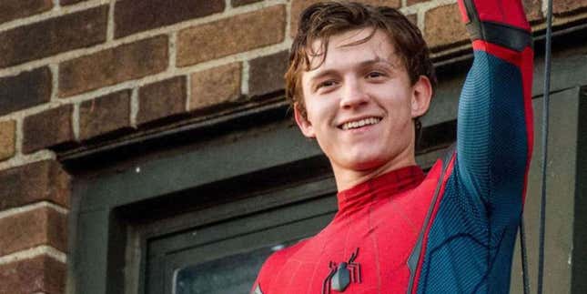 Tom Holland in the Spider-Man costume, smiling and waving. 