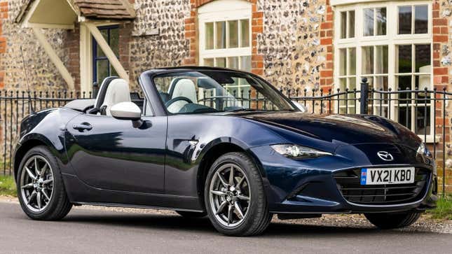 Una foto de un auto deportivo Mazda Miata azul oscuro. 