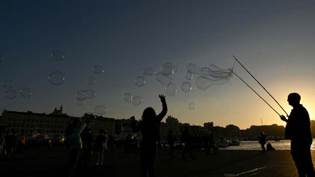 A photo of a man blowing giant bubbles