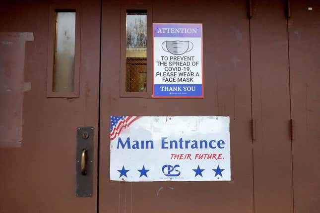 A sign on the door of Lowell elementary school asks students, staff, and visitors to wear a mask to prevent the spread of COVID-19 on January 05, 2022, in Chicago, Illinois. Classes at all of Chicago public schools have been canceled today by the school district after the teacher’s union voted to return to virtual learning, citing unsafe conditions in the schools as the Omicron variant of the coronavirus continues to spread. 