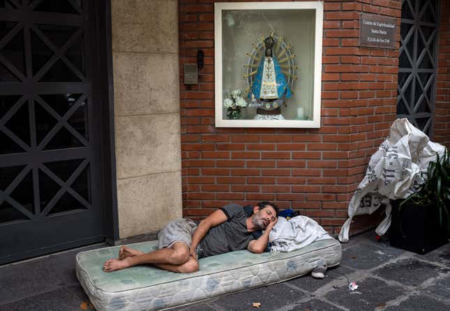 Agustin Catamano, 48, who said he is homeless, sleeps in front of a Catholic institution in Buenos Aires, Argentina, Sunday, Feb. 18, 2024. (AP Photo/Rodrigo Abd)