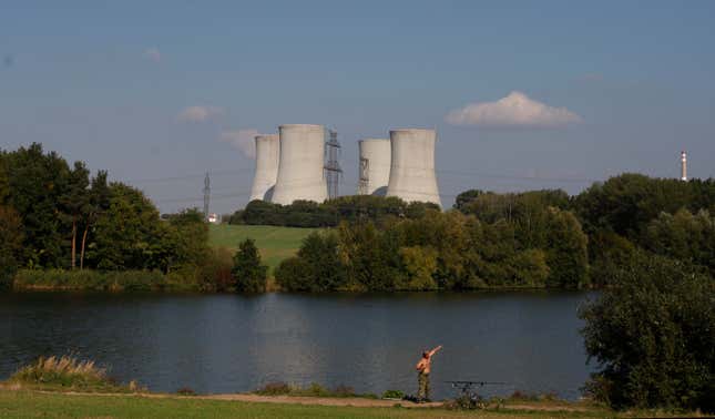 FILE - A man fishes with the towering Dukovany nuclear power plant in the background, in Dukovany, Czech Republic, Sept. 27, 2011. On Tuesday Oct. 31, 2023, three energy companies including U.S. Westinghouse, France&#39;s EdF and Korea&#39;s KHNP, have submitted their final bids to build the Czech Republic&#39;s newest reactor at the Dukovany nuclear power station as the country strives to become more energy independent and wean itself of fossil fuels. (AP Photo/Petr David Josek, File)