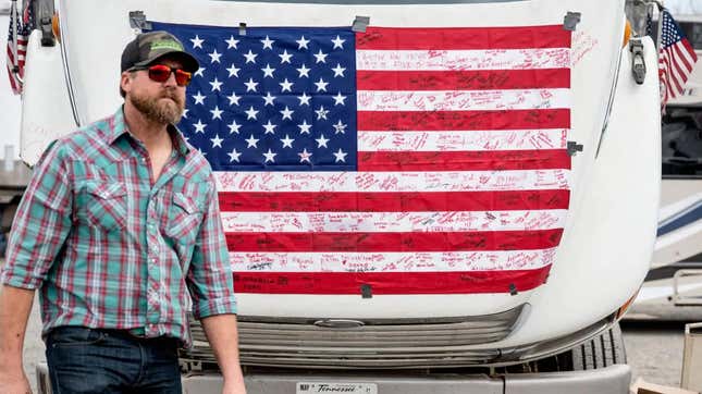 A demonstrator passes an autographed American flag as he prepares to depart Hagerstown Speedway in Hagerstown, Maryland, on March 7, 2022.