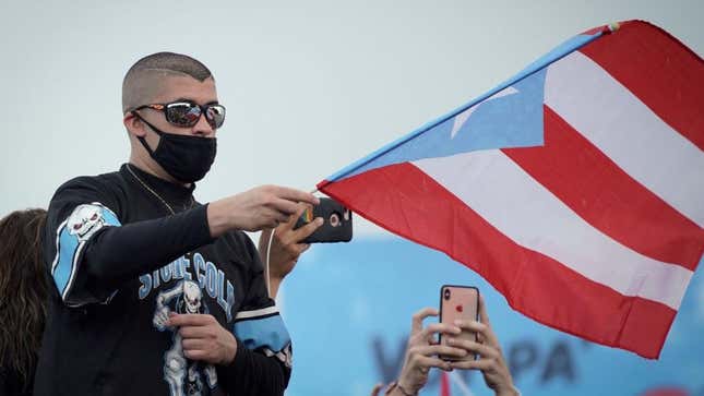 Bad Bunny waves a flag during a 2019 national strike demanding Puerto Rico’s Governor Ricardo Rossello resignation. 