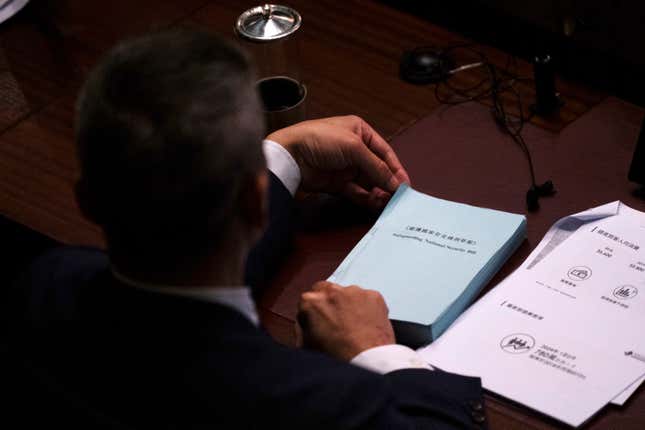 FILE - A lawmaker holds a copy of the proposed Safeguarding National Security Bill at the Legislative Council in Hong Kong, March 19, 2024. The United States sees Hong Kong&#39;s new national security law as a tool to potentially silence dissent both at home and abroad, but has tread carefully so far in responding, a disappointment to those fighting for democracy and freedoms in the Chinese territory. (AP Photo/Louise Delmotte, File)