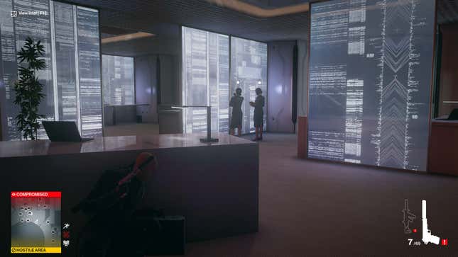 Agent 47 crouches below an office desk to hide from two NPCs.
