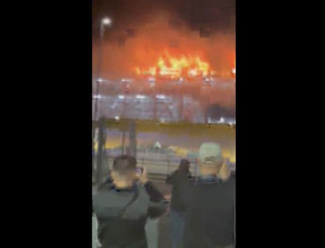 This image taken from video provided by Molly Bullard, shows a fire that broke out in one of the parking lots at Luton Airport, in Luton, England, Tuesday, Oct. 10, 2023. Luton Airport, located about 35 miles (56 kilometers) north of central London, said that “all flights are currently suspended as emergency services respond to a car fire that has spread in Terminal Car Park 2.” (Molly Bullard via AP)