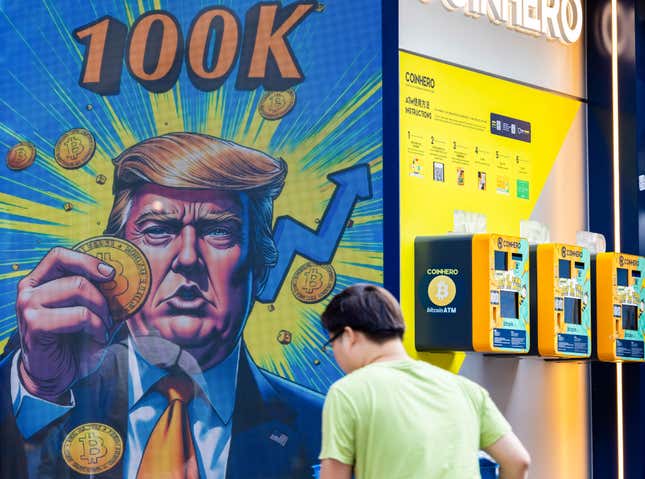 A cartoon image of US President-elect Donald Trump holding a Bitcoin token to mark the cryptocurrency reaching over $100,000 displayed at a Coinhero store in Hong Kong, China, on in Hong Kong, China, on Thursday, Dec. 5, 2024. 