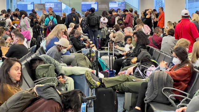 Travelers wait to board a plane at Miami International Airport in Miami, Florida, on April 22, 2022.