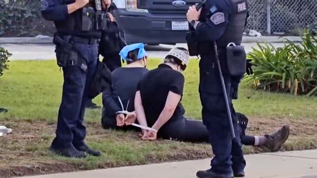 This video still image provided by KABC-TV shows protesters being detained prior to arrested by Los Angeles police officers on Wednesday, Dec. 27, 2023 near Los Angeles International Airport. Pro-Palestinian protesters briefly blocked entrance roads to airports in New York and Los Angeles on Wednesday, forcing some travelers to set off on foot to bypass the jammed roadway. (KABC-TV via AP)