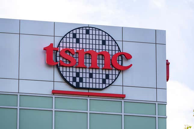 close up of red TSMC letters on a logo shaped like a wafer board on the corner of a building