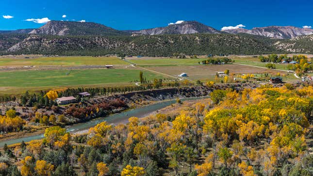 A photo of a highway passing between rivers and mountains. 