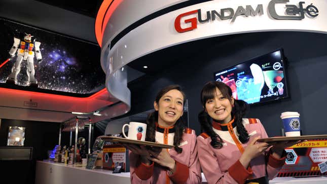 Staff at the Gundam Cafe in Akihabara wear Gundam themed outfits and hold trays with drinks. 