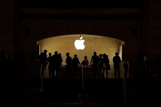 Silhouettes of people browsing in the Grand Central Apple store. 