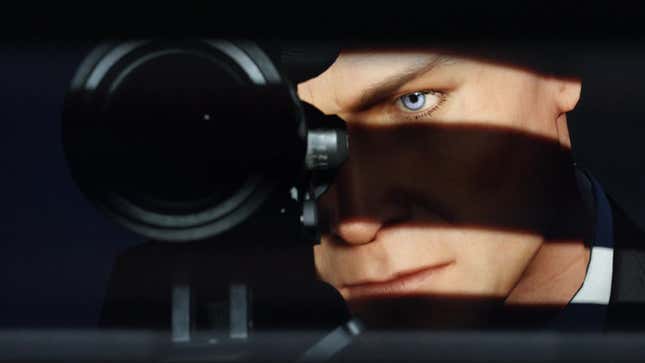 Agent 47 aims down the sites of a sniper rifle.