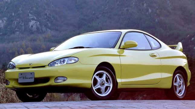 A photo of a yellow Hyundai Tiburon sports car. 