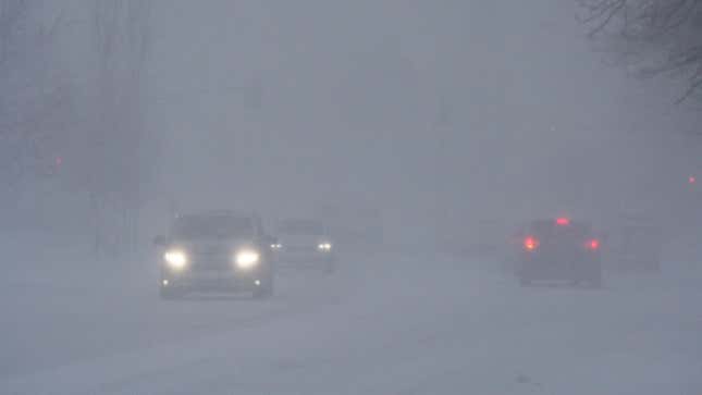 Una foto de automóviles circulando durante una tormenta de nieve. 