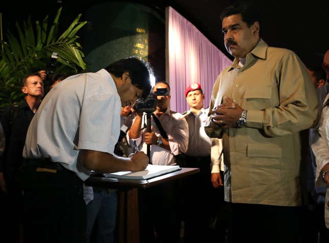 President Nicolas Maduro (R) and Bolivia's President Evo Morales (L) sign a book of condolences as they pay tribute to Cuba's late President Fidel Castro at the Jose Marti Memorial in Revolution Square in Havana, Cuba