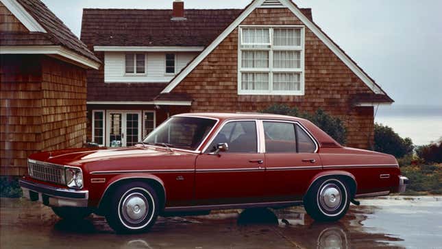 Una foto de un Chevrolet Nova de 1976 estacionado afuera de una casa. 