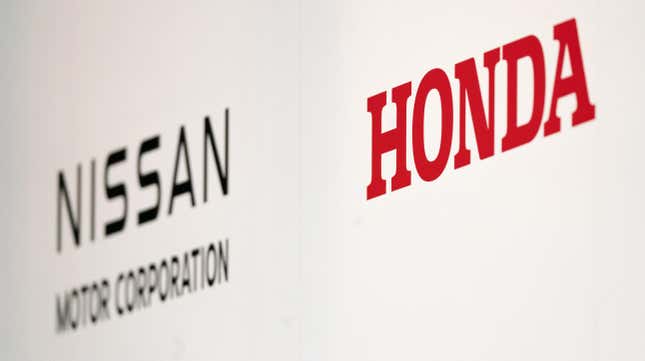 Nissan Motor and Honda Motor logos are seen during a joint press conference on December 23, 2024, in Tokyo, Japan. Nissan and Honda announced they have begun merger negotiations, aiming to create the world's third-largest automotive group to compete with rival EV manufacturers such as China's BYD and the US-based Tesla.