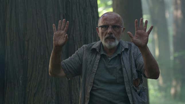 Eugene stands with his hands up.
