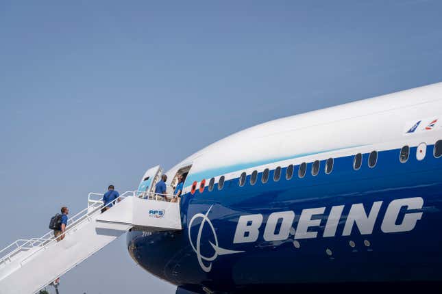 Los visitantes suben las escaleras para hacer un recorrido por un avión a reacción Boeing 777X en Farnborough, Inglaterra.