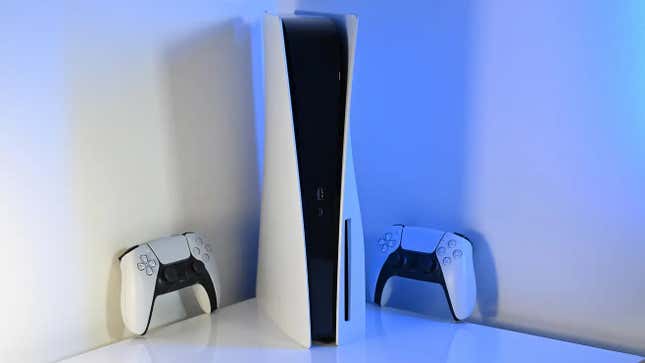 A PlayStation 5 console on a white background surrounded by two DualSense controllers.