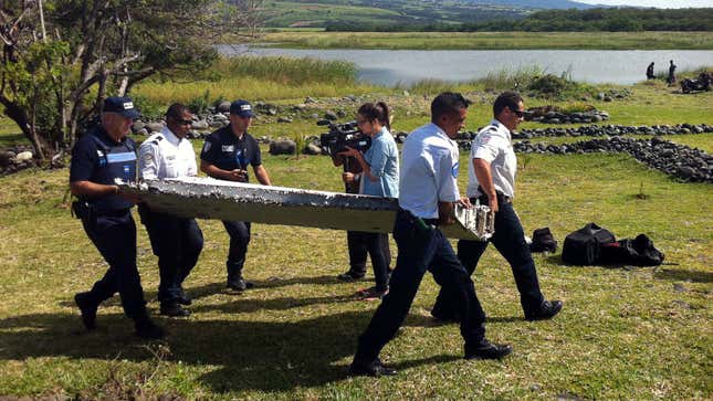 A photo of people carrying a wing fragment. 