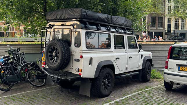 Rückansicht 3/4 eines weißen Land Rover Defender