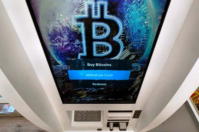 FILE - The Bitcoin logo appears on the display screen of a cryptocurrency ATM in Salem, N.H., Feb. 9, 2021. The U.S. for the first time has given the greenlight to almost a dozen exchange traded funds for bitcoins. ETFs give every day investors a way to get in on trading in oil, gold, corporate bonds and now bitcoin without actually having to own a bar of gold, a barrel of oil, or a bitcoin. (AP Photo/Charles Krupa, File)