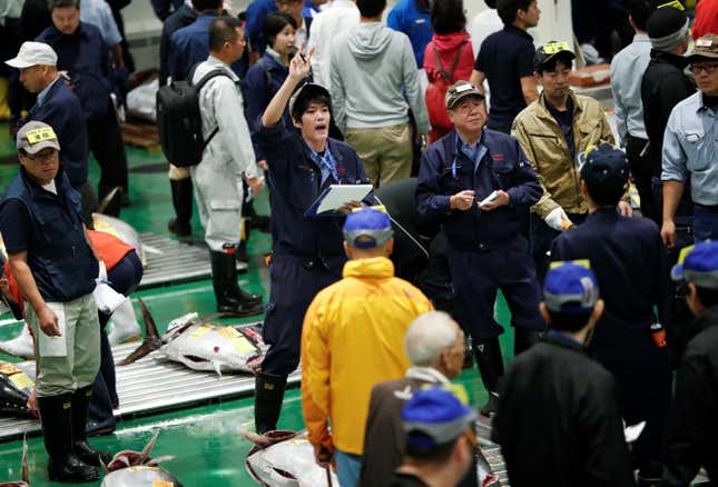 An auctioneer gestures during one of the the first tuna auctions on the opening day of the new Toyosu fish market.