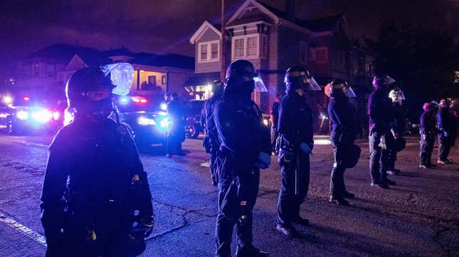 Oakland police officers line the street as demonstrators confront the officers during a protest against police brutality in Oakland, Calif., on Friday, April 16, 2021. 