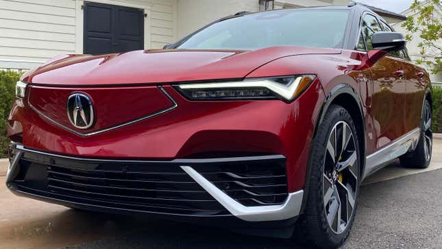 A close-up of the front 3/4 of a red Acura ZDX Type S showing the headlights and grille