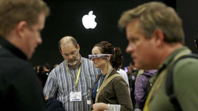 A woman wears a pair of glasses-like AR goggles underneath the Apple symbol.