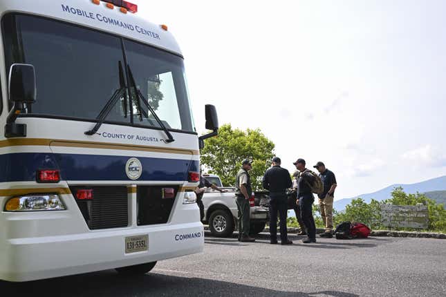 A mobile command center bus and government officials in the Washington National Forest in Virginia