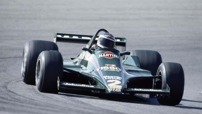 A vintage photo of Carlos Reutemann driving a green Formula 1 race car. 