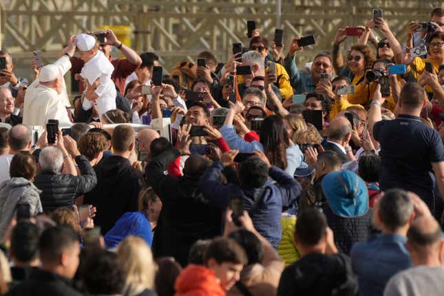 Pope Francis blesses a child wearing a pontiff costume as he tours St. Peter&#39;s Square on the popemobile during the weekly general audience at the Vatican, Wednesday, Nov. 15, 2023. (AP Photo/Gregorio Borgia)