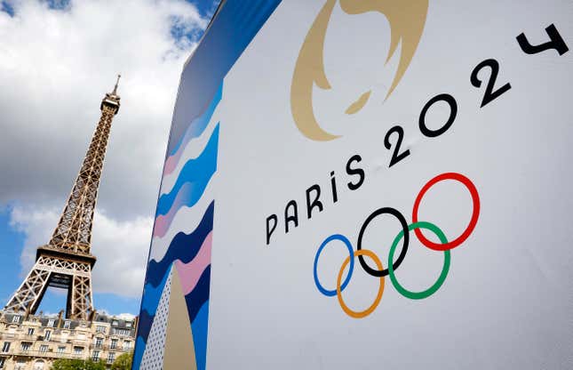 The Paris 2024 logo, representing the Olympic Games is displayed near the Eiffel Tower three months prior to the start of the Paris 2024 Olympic and Paralympic games on April 21, 2024 in Paris, France.