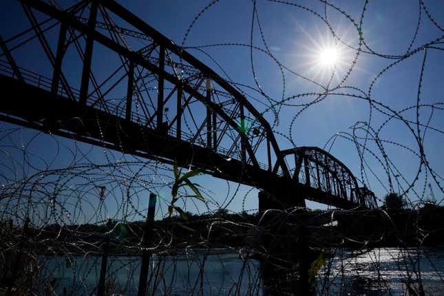 FILE - The Union Pacific International Railroad Bridge is seen behind concertina wire, Sept. 22, 2023, in Eagle Pass, Texas. The federal government on Friday, Dec. 22, reopened railroad crossings in two Texas border towns, including Eagle Pass, days after the shuttering of rail operations there disrupted trade and caused outrage. (AP Photo/Eric Gay, File)