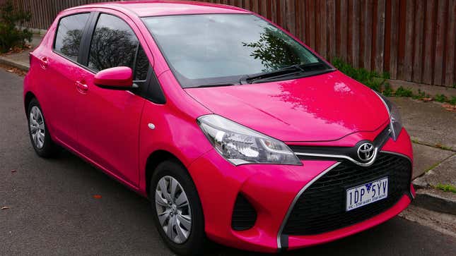 A photo of a bright pink Toyota Yaris hatchback. 