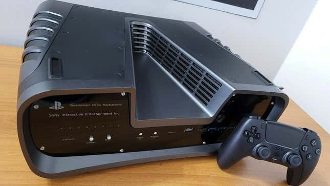 A V-shaped PlayStation 5 dev kit sits on a wooden table.