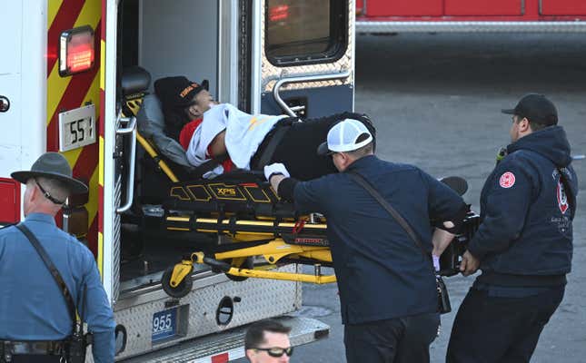Medical personnel load a woman into an ambulance after a shooting at  Union Station after the Kansas City Chiefs Super Bowl LVIII victory  parade