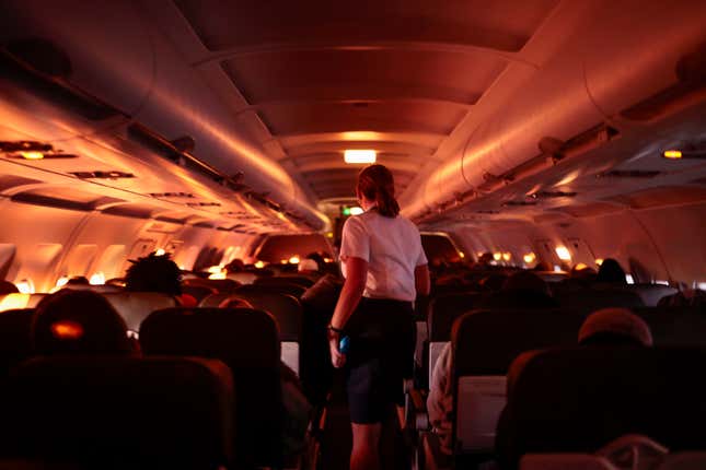 DALLAS, TX - NOVEMBER 24: A flight attendant walks through an airplane before the plane’s descent into the Dallas/Fort Worth International Airport on November 24, 2021 in Dallas, Texas. FAA expects the number of travelers for Thanksgiving to reach pre-pandemic levels, with more than 53 million people traveling in total in the days leading up to the holiday. 