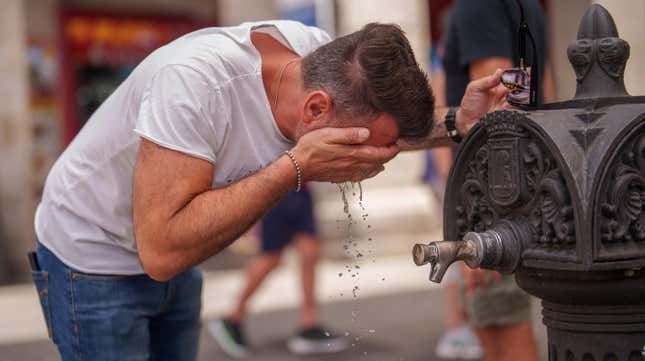 A man cool off in a fountain during a hot and sunny day of summer in Madrid, Spain, July 19, 2023.
