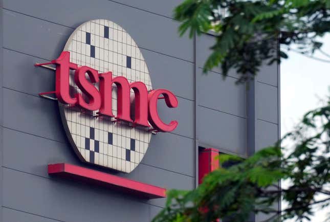 Logo TSMC en lettres rouges sur plaquette dans un immeuble de bureaux