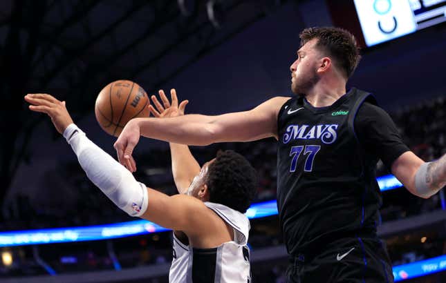 DALLAS, TX - FEBRUARY 14: Luka Doncic #77 of the Dallas Mavericks blocks the shot of Keldon Johnson #3 of the San Antonio Spurs in the second half at American Airlines Center on February 14, 2024 in Dallas, Texas. NOTE TO USER: User expressly acknowledges and agrees that, by downloading and or using this photograph, User is consenting to the terms and conditions of the Getty Images License Agreement. (Photo by Ron Jenkins/Getty Images)
