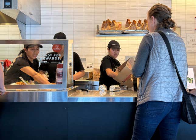 Workers help a customer at a Chipotle restaurant on April 01, 2024 in San Rafael, California. 