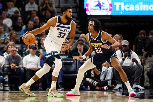 Nov 1, 2023; Minneapolis, Minnesota, USA; Minnesota Timberwolves center Karl-Anthony Towns (32) dribbles while Denver Nuggets forward Zeke Nnaji (22) defends during the first half at Target Center.