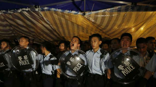 Police officers shout as they instruct the protesters to move to a nearby park at the main roads outside government headquarters in Hong Kong